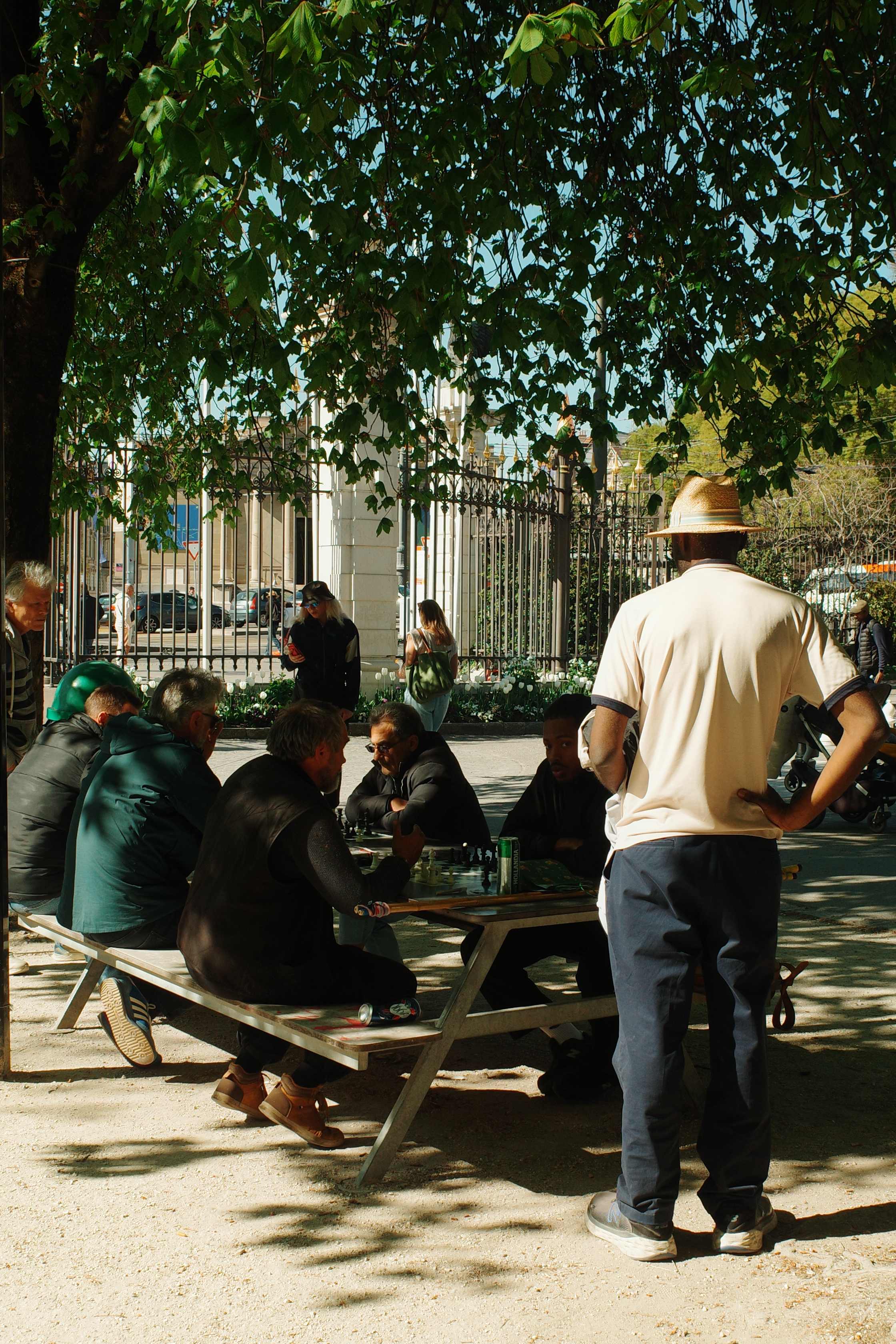 Men gathered around a chess game outdoors
