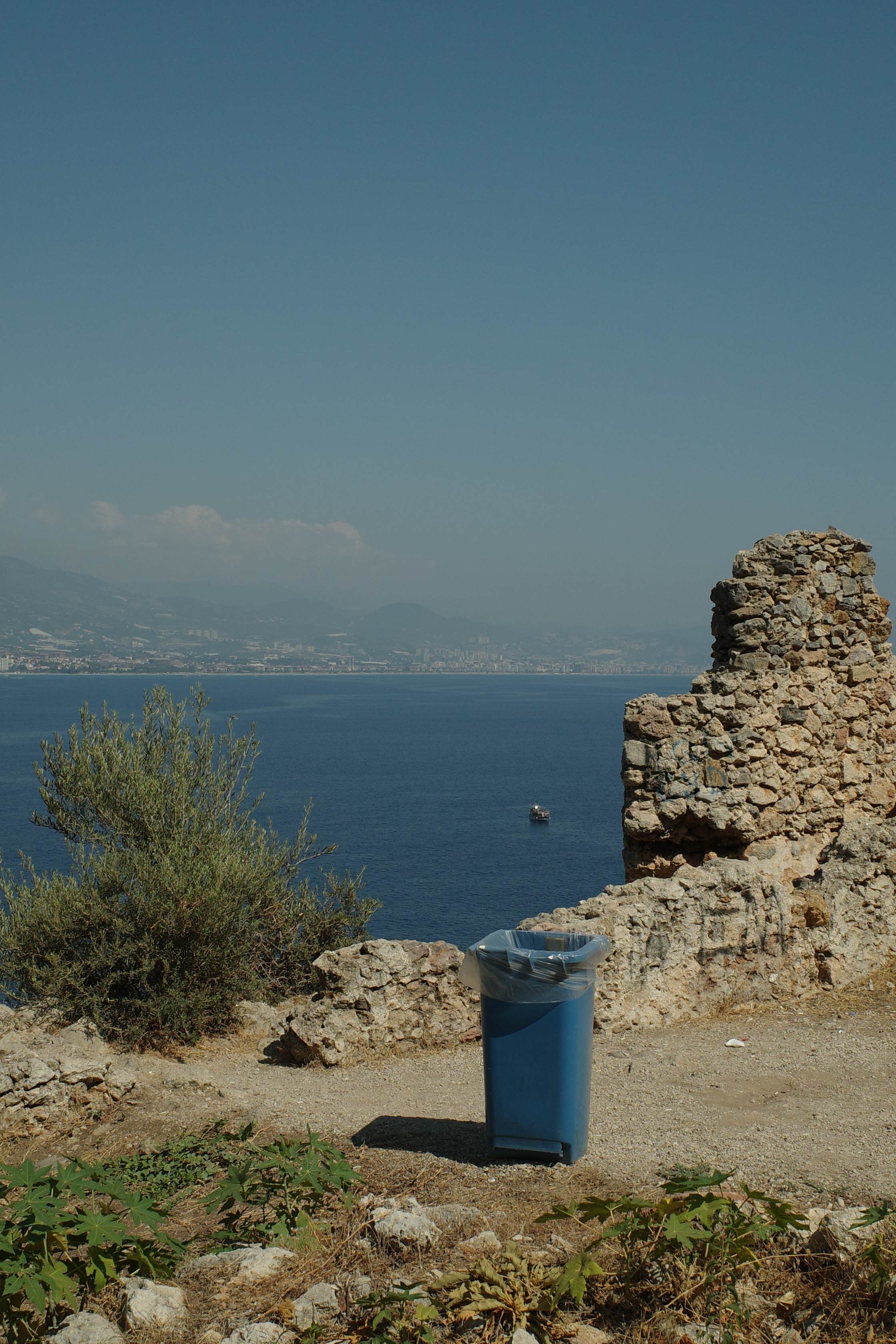 Blue trash can overlooking the sea